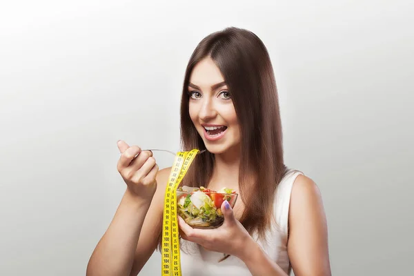 Comida saudável. Menina sorridente em sportswear segurando um copo de sala — Fotografia de Stock