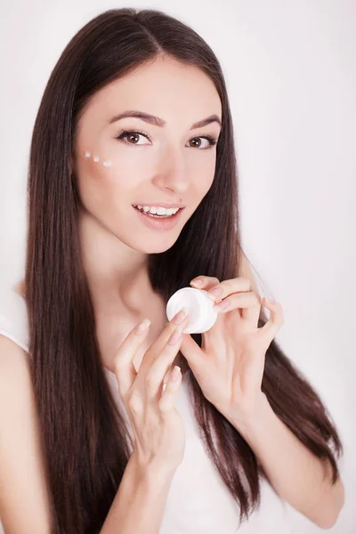 Donna con viso sano applicare crema cosmetica sotto gli occhi — Foto Stock