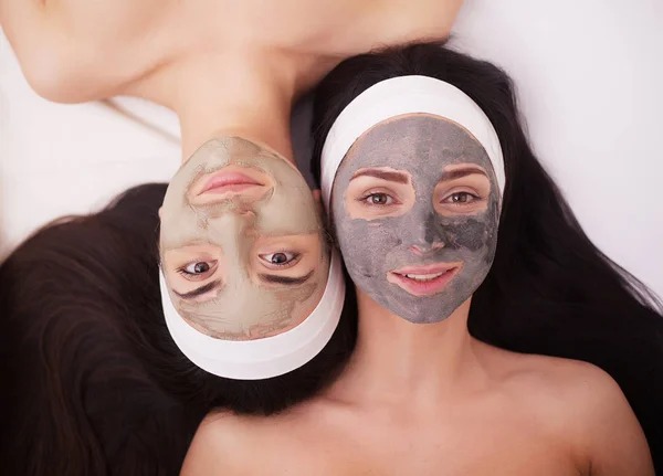 Uso di una maschera per il viso due giovani donne in un salone di bellezza — Foto Stock