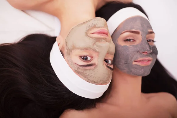 Využívání obličejovou masku na obličej dvě mladé ženy v salonu krásy — Stock fotografie