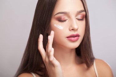 kadın sağlıklı yüzü gözlerimin altında kozmetik krem uygulamak