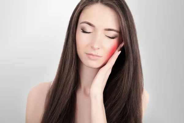 Kadın acı içinde. Yüz el ile dokunmak güzel genç kadın duygu ağrılı diş ağrısı, closeup. Üzgün kız güçlü diş, çene ya da boyun ağrısı duygu vurguladı. Diş sağlığı ve bakımı. Yüksek çözünürlük