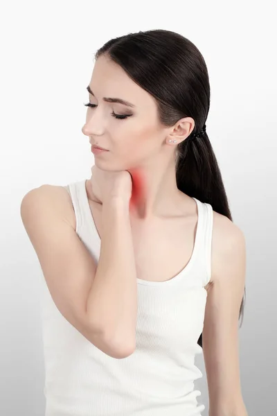 Rear view of a young women holding her neck in pain. isolated on white background. monochrome photo with red as a symbol for the hardening. — Stock Photo, Image