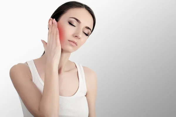 Kadın acı içinde. Yüz el ile dokunmak güzel genç kadın duygu ağrılı diş ağrısı, closeup. Üzgün kız güçlü diş, çene ya da boyun ağrısı duygu vurguladı. Diş sağlığı ve bakımı. Yüksek çözünürlük