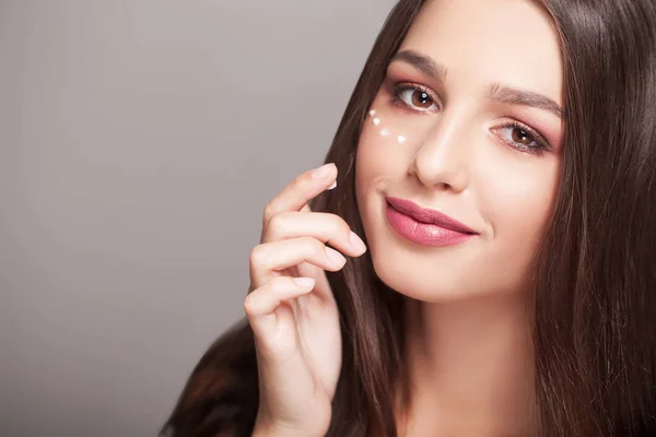 Cuidado facial. Retrato de mujer joven atractiva con gotas de cosmético — Foto de Stock