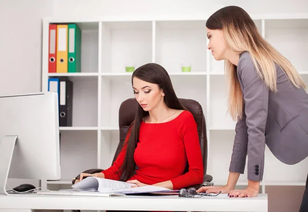 Two businesswomen working together.Girl is sitting at table in f — Stock Photo, Image