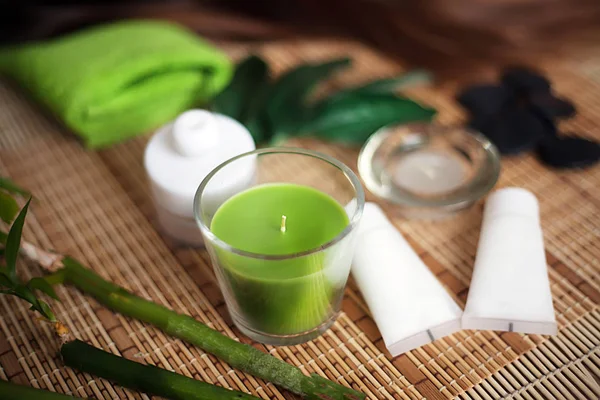 Herramientas de spa verde con vela y toalla en madera — Foto de Stock