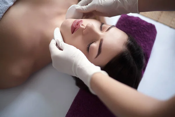 Massaggiatore facendo massaggiare la testa di una donna adulta nel salone spa — Foto Stock