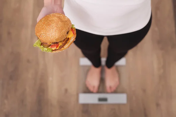 Conceito de dieta e fast food. Mulher com excesso de peso em pé no peso — Fotografia de Stock