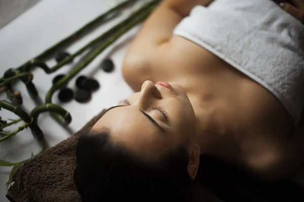 Immagine di una donna nel salone spa sdraiata sulla scrivania del massaggio — Foto Stock