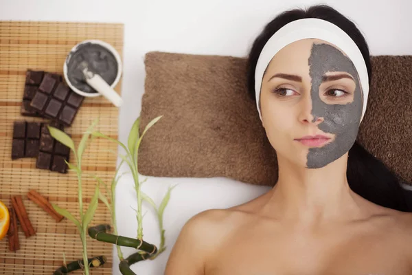 Spa masaż dla młodej kobiety z twarzy maski na twarz - wewnątrz — Zdjęcie stockowe