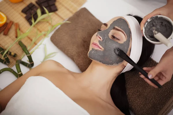 Spa massage för ung kvinna med ansiktsmask på face - inomhus — Stockfoto