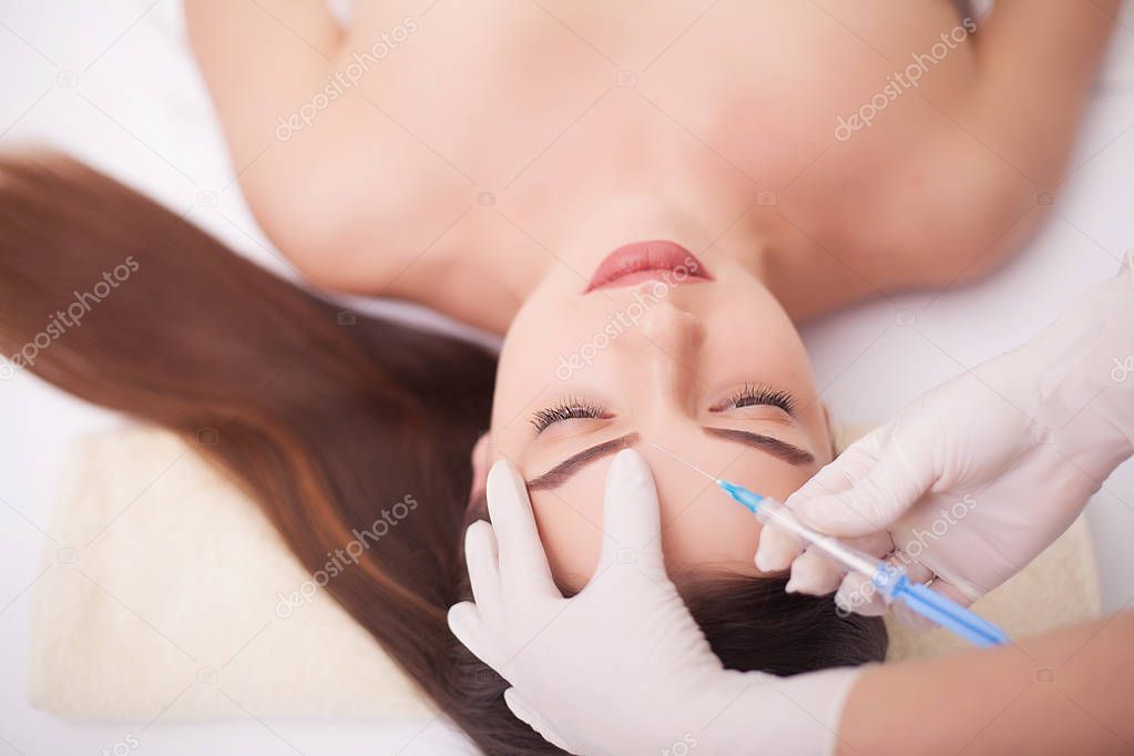 Injection And Woman Beauty Face. Attractive girl with perfect skin. Woman in spa ,massage the back, smooth skin. Beauty and youthfulness of the skin, facial treatments at the beauty salon