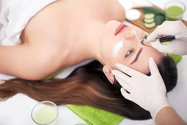 Hardware cosmetologie. Close-up foto van mooie jonge vrouw met crème masker in een schoonheidssalon. — Stockfoto