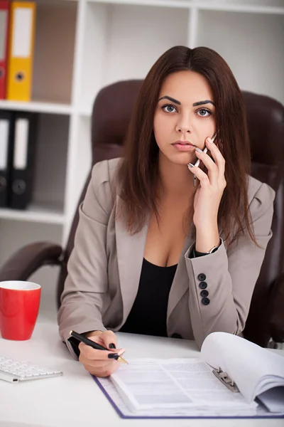 Leende svart affärskvinna på telefon på skrivbordet — Stockfoto