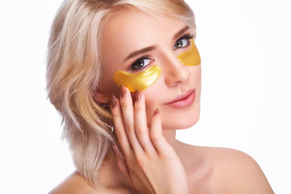 Yama gözlerinin altında. Güzel bir kadın yüzü ile altın hidrojel Patche