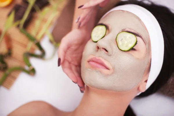 Wanita muda cantik mendapatkan masker tanah liat wajah di spa, berbohong — Stok Foto