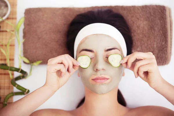 Mulher bonita está recebendo máscara de barro facial no spa, deitado — Fotografia de Stock