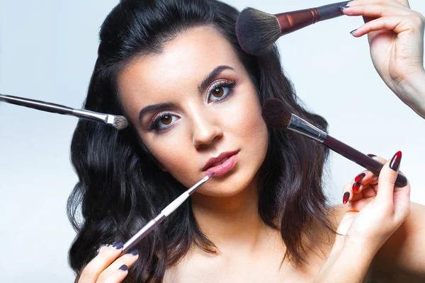 Primer plano de la cara de la mujer joven con todo tipo de herramientas de maquillaje - b — Foto de Stock