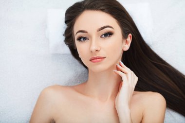 Güzel genç bir kadın güzellik salonunda yüz bakımı yaptırıyor..