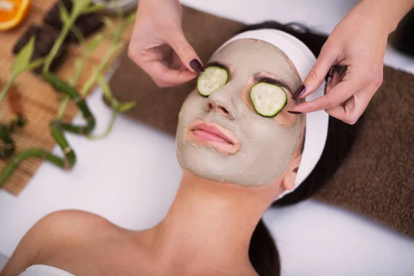 Spa. Hermosa joven mujer está recibiendo máscara de arcilla facial en el spa, l — Foto de Stock