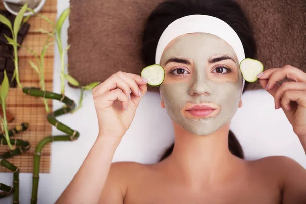 Spa. Beautiful young woman is getting facial clay mask at spa, l — Stock Photo, Image