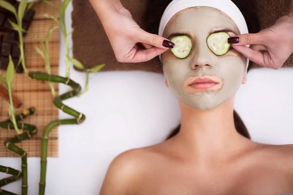 Spa. Hermosa joven mujer está recibiendo máscara de arcilla facial en el spa, l — Foto de Stock