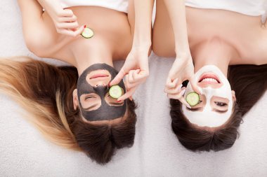 İki kız arkadaş ove üzerinde yüz maskeleri ile rahatlatıcı bir resim