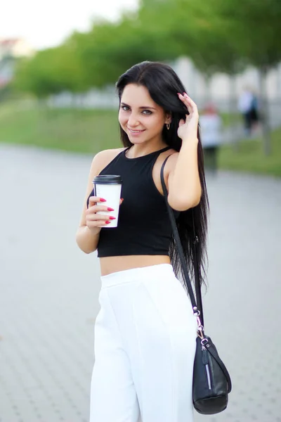 Femme gaie dans la rue buvant le café du matin au soleil — Photo