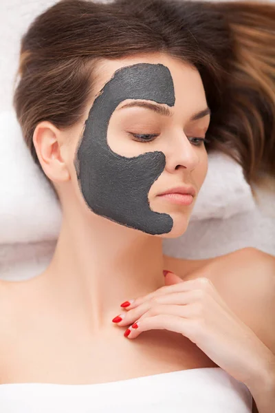 Hermosa mujer con máscara cosmética en la cara. Chica consigue tratamiento — Foto de Stock