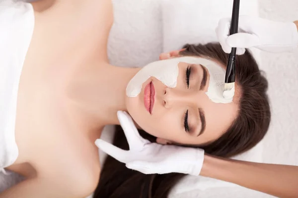 Spa. Attraente donna divertente con una maschera di argilla sul viso. — Foto Stock