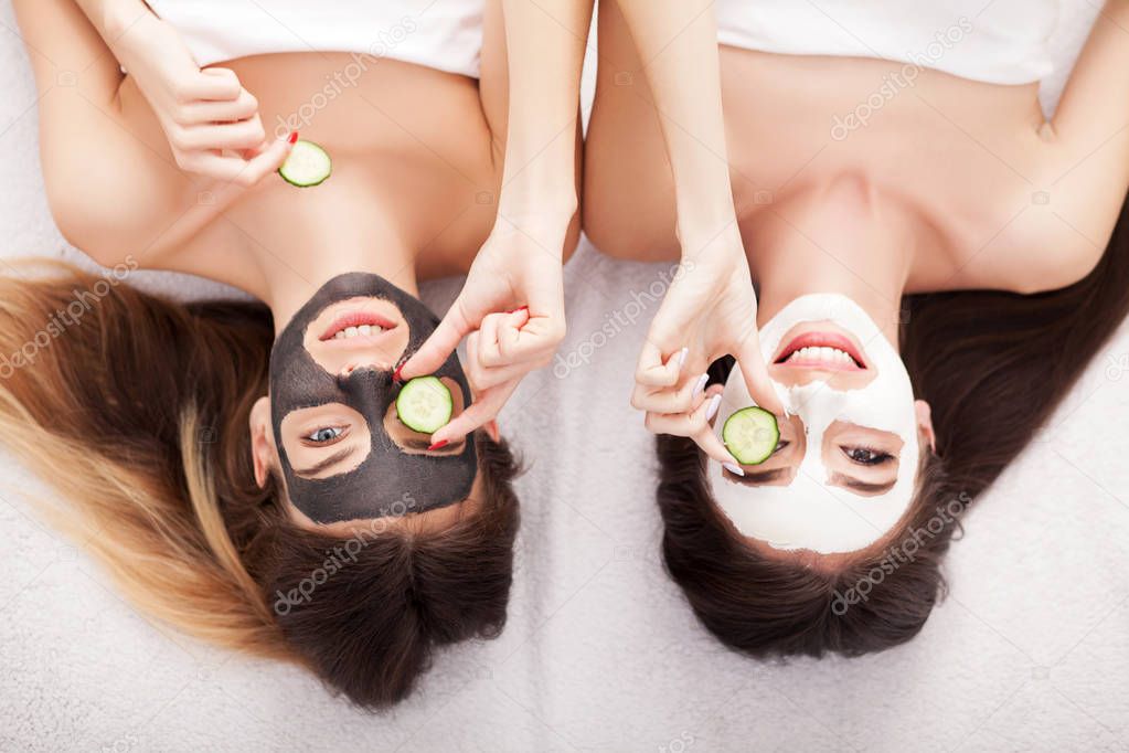 A picture of two girls friends relaxing with facial masks on ove