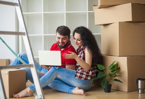Glada unga par uppackning eller packa lådor och flytta in i en — Stockfoto