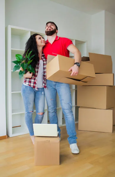 Молода пара розпаковує картонні коробки в новому будинку. . — стокове фото