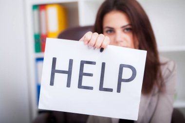 Yardım için yalvaran, bir karton tutan stresli iş kadını 