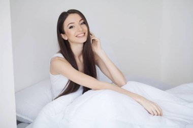 Beyaz Yatak çarşaflar takımlar evde yatakta uyuyan genç kadın. Re