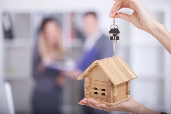 Säljare som transporterar ett modell hus i hand levererar huset — Stockfoto