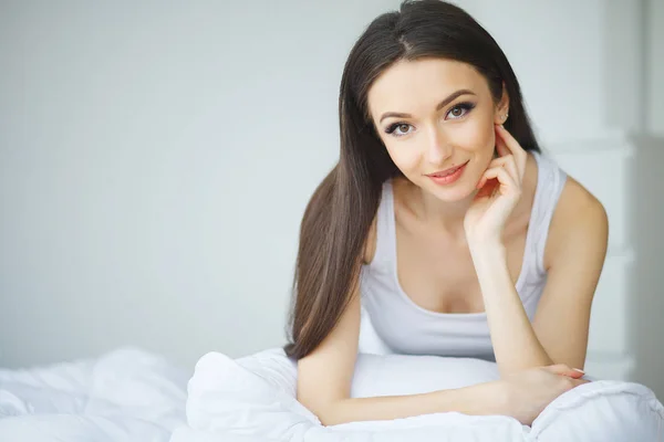Portrait pretty young girl on bed in modern apartment in the mor — Stock Photo, Image