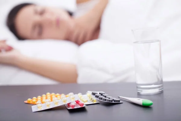眠っている不健康な女性やナイト テーブルの上の薬 — ストック写真