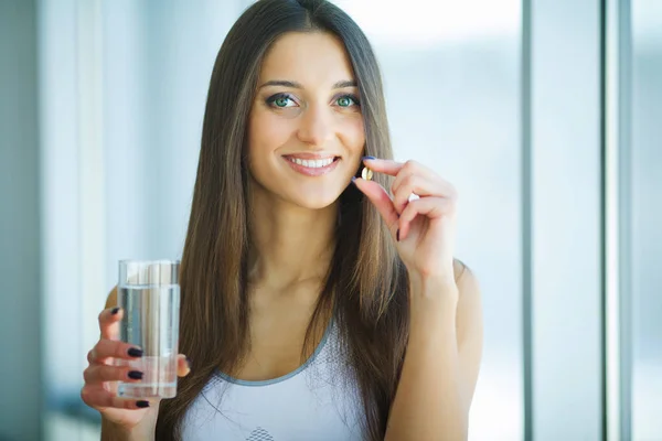 Mulher sorridente bonita tomando pílula de vitamina. Suplemento dietético — Fotografia de Stock