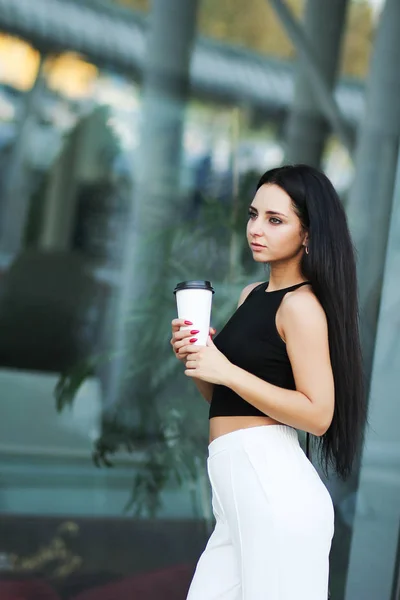Jeune belle femme d'affaires boit du café près du bureau — Photo