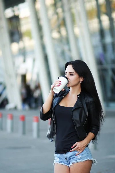 Νεαρή όμορφη γυναίκα πίνει καφέ κοντά στο δίπλα γραφείο — Φωτογραφία Αρχείου