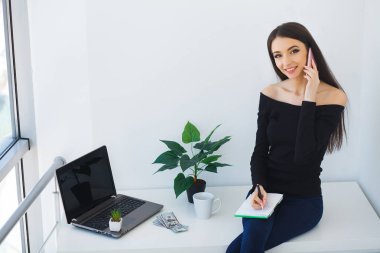 ofiste dizüstü bilgisayarda çalışan genç kadın