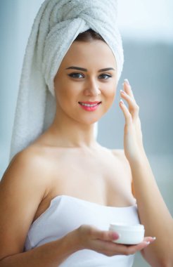 Stüdyo çekim güzel genç kadının nemlendirici krem uygulamak 