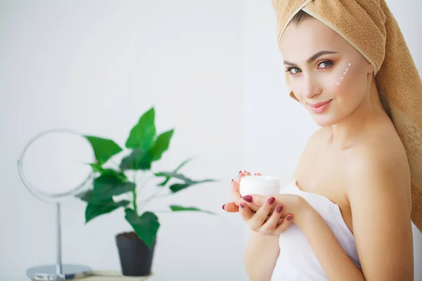 Porträt einer schönen Frau, die ihr Gesicht eincremt — Stockfoto