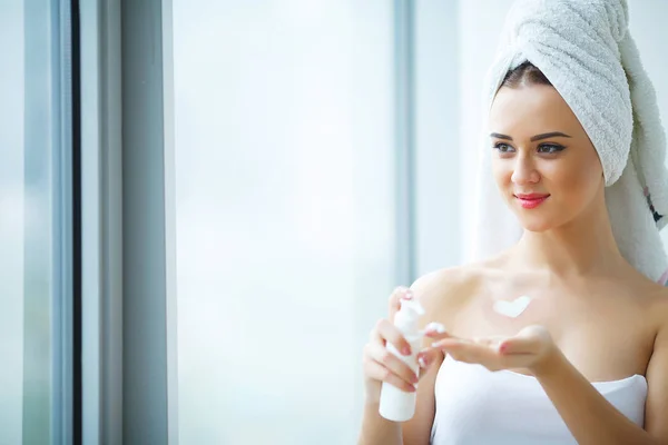 Studio shot van mooie jonge vrouw toepassing moisturizer crème — Stockfoto