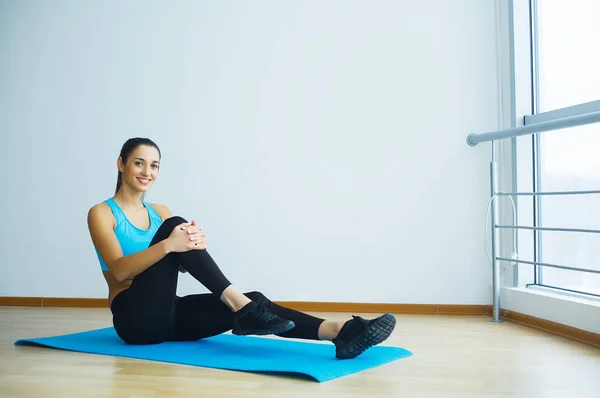 Güzel gülümseyen kadın kapalı spor salonunda yoga yaparken. — Stok fotoğraf