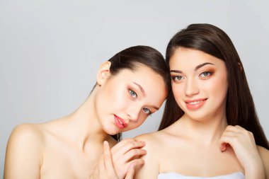 İki güzel seksi kadın ne studio poz ve krem holding