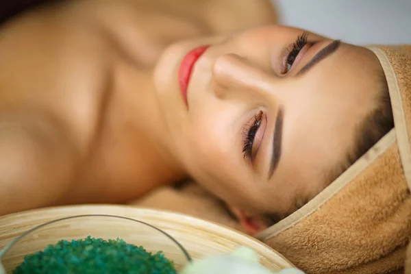 Spa. Młoda kobieta na stole do masażu w spa salon piękności — Zdjęcie stockowe