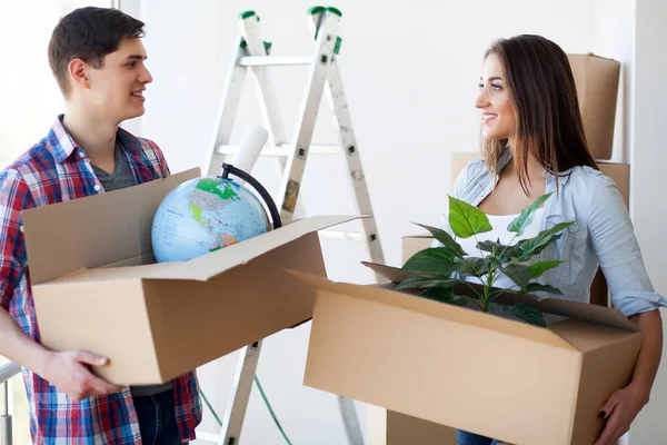 Ένα ζευγάρι με κουτιά κινείται προς ένα νέο σπίτι. Ακίνητα προς πώληση. — Φωτογραφία Αρχείου